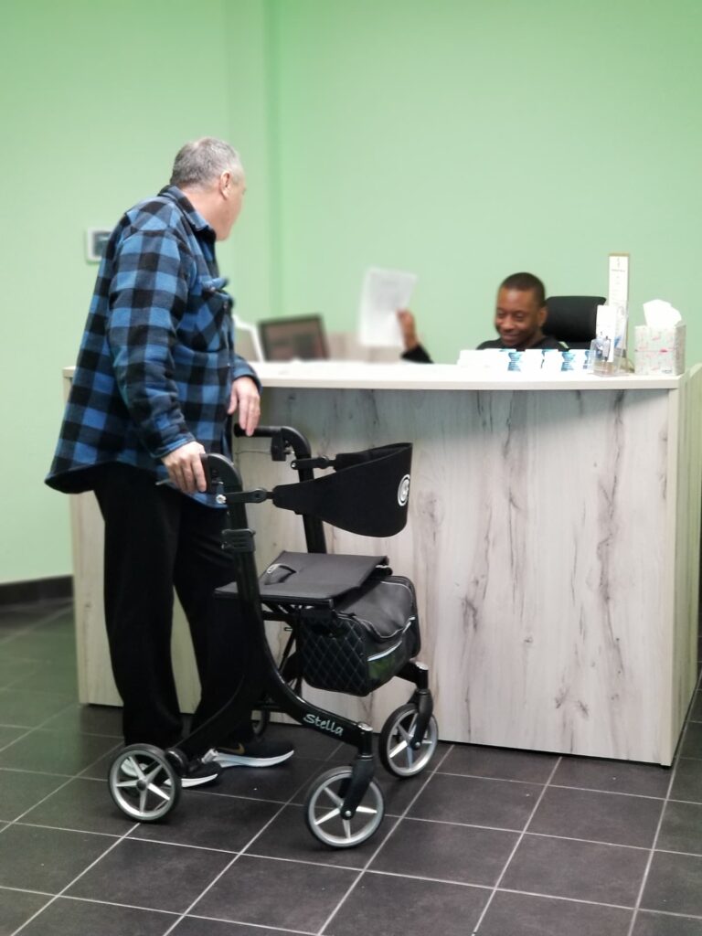 patient with wheel chair consulting with receptionist 